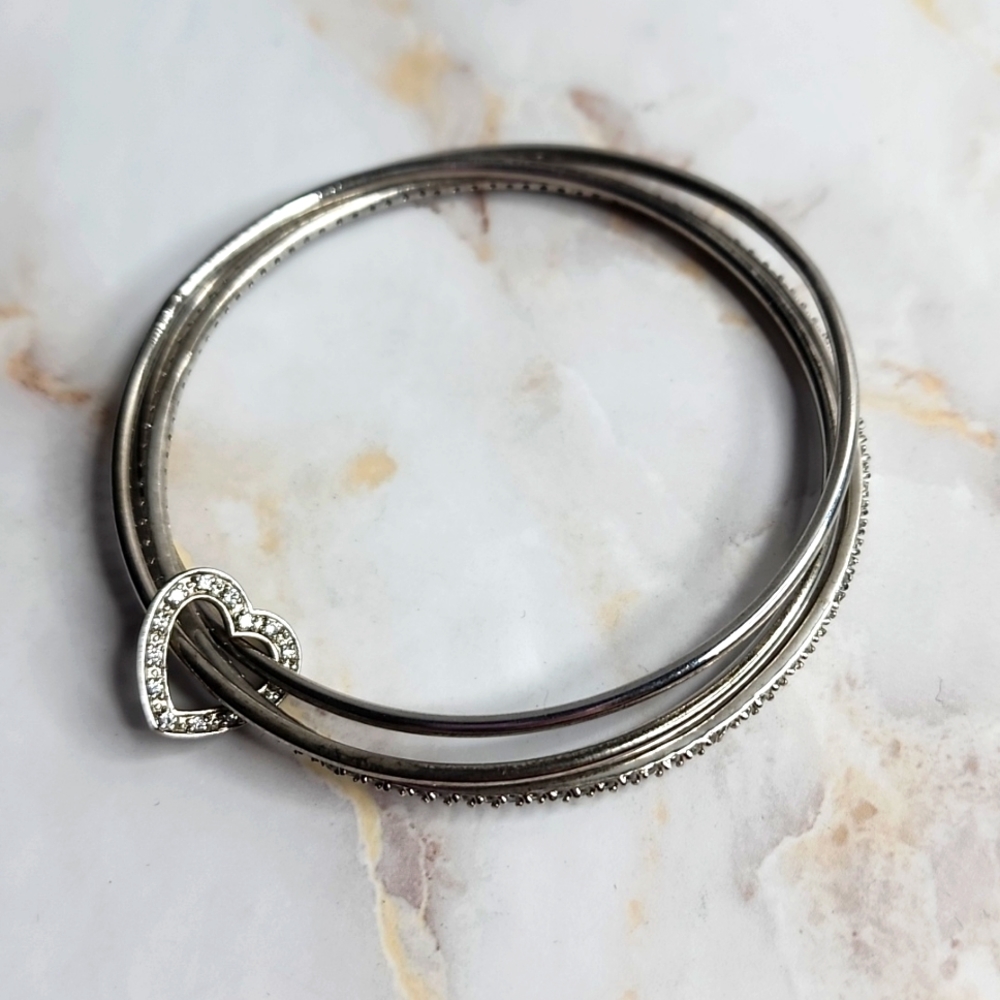 3 sterling silver bangles connected with by a  heart